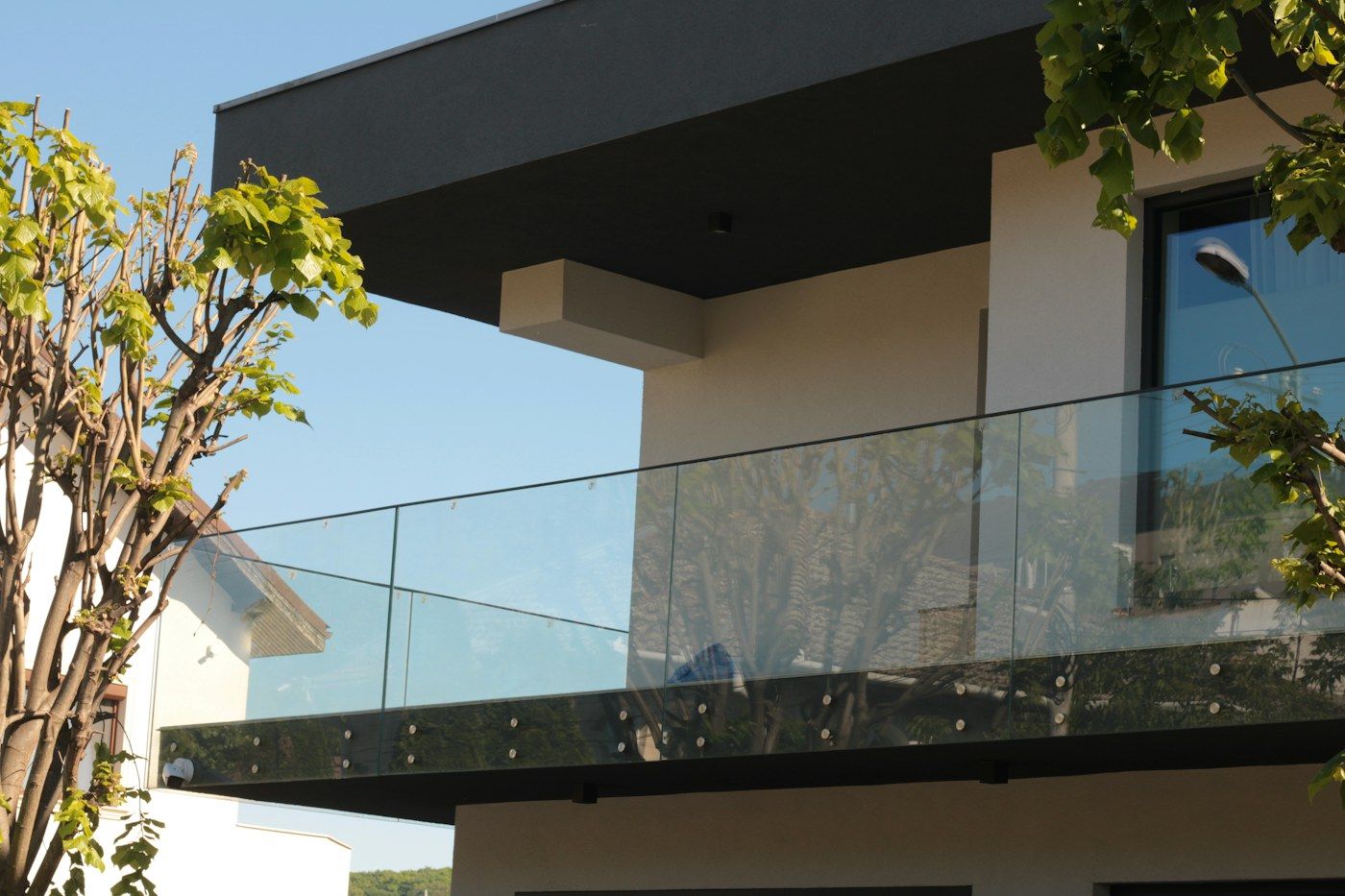 Sacada de casa com guarda-corpo de vidro transparente e céu ao fundo