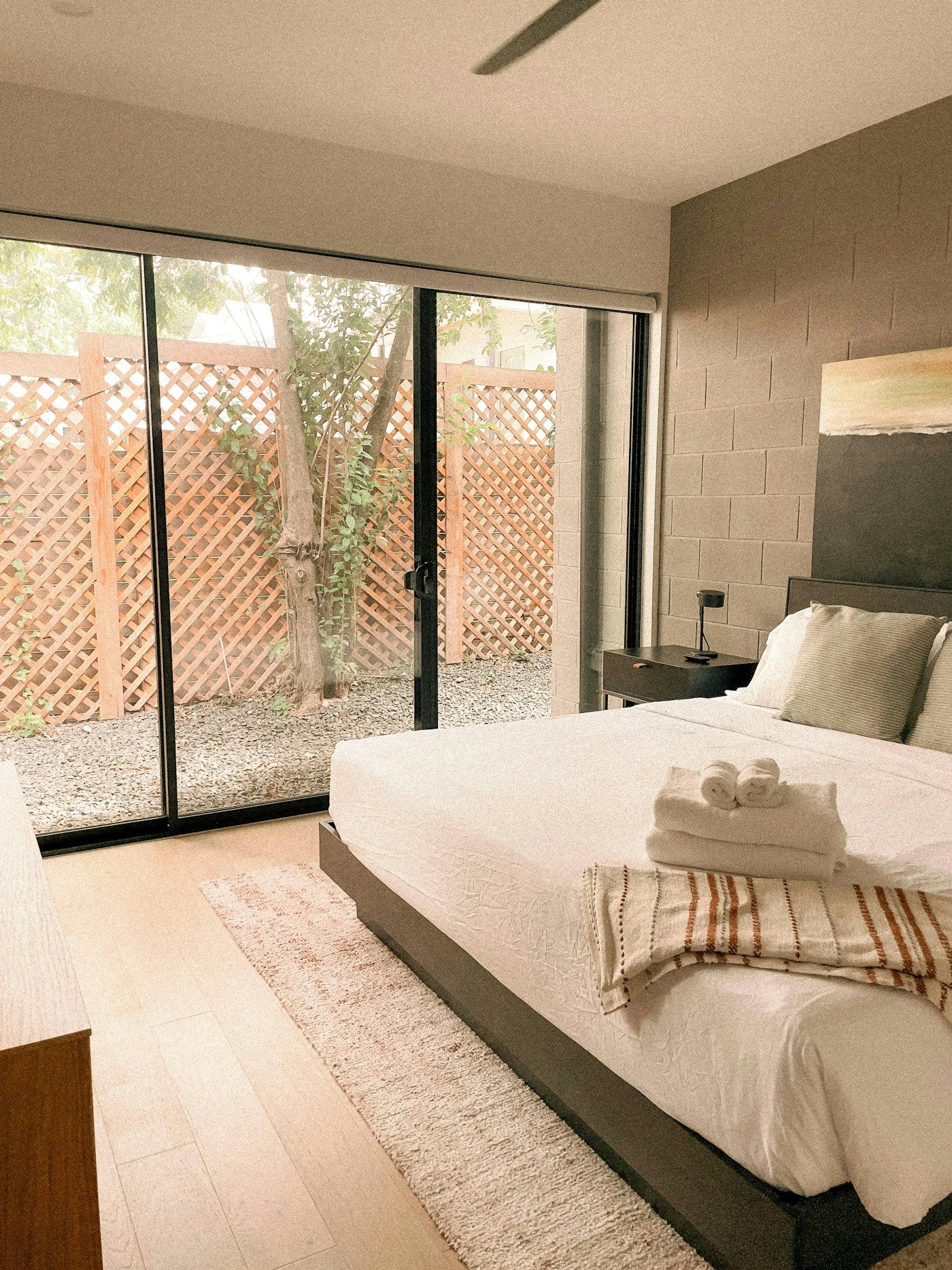 Quarto com grandes portas de vidro de correr abrindo para um pátio